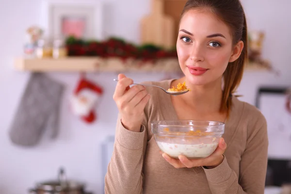 Mujer atractiva sonriente desayunando en el interior de la cocina — Foto de Stock