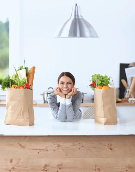 Portrait of a smiling woman cooking in her kitchen sitting — Stock Photo, Image