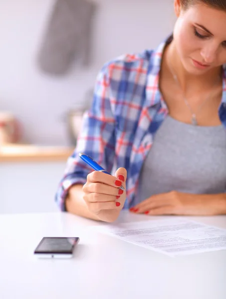 Vacker ung kvinna skriver något i sin anteckningsblock — Stockfoto