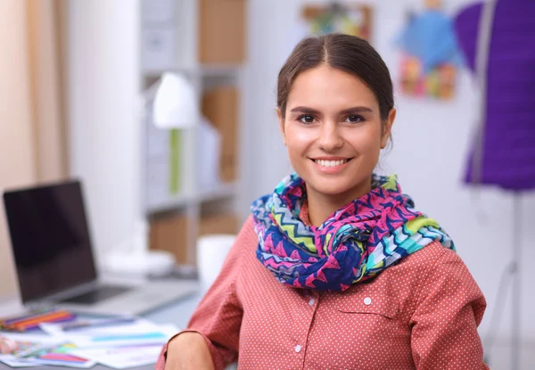 Joven y atractiva diseñadora de moda femenina trabajando en el escritorio de la oficina, dibujando mientras habla en el móvil —  Fotos de Stock