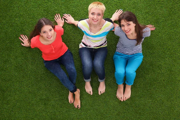 Young women sitting  on green grass Stock Picture