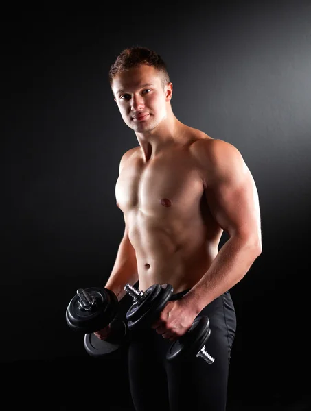 Handsome muscular man working out with dumbbells — Stock Photo, Image