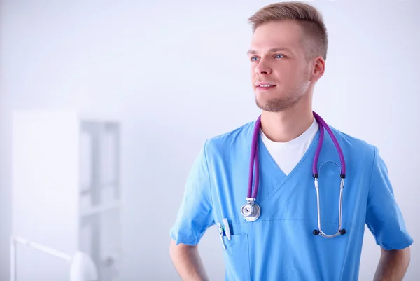 Médico com estetoscópio em pé, sobre fundo branco — Fotografia de Stock