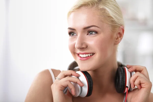 Joven hermosa mujer en casa sentada en el sofá y escuchando música —  Fotos de Stock