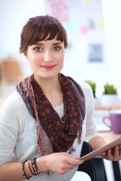 Young attractive fashion designer standing by desk in office, holding folders — Stock Photo, Image