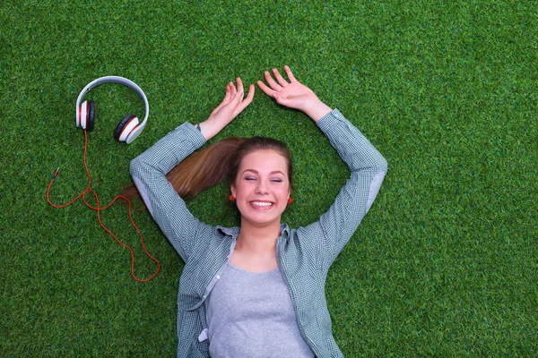Relaxed woman  lying on the grass near headset — Stock Photo, Image