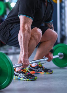 spor salonunda barbell ile vücut geliştirmeci