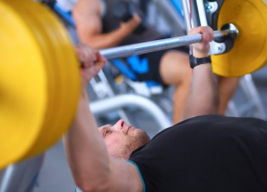 Genç adam eğitmen ile spor salonunda halter kaldırma