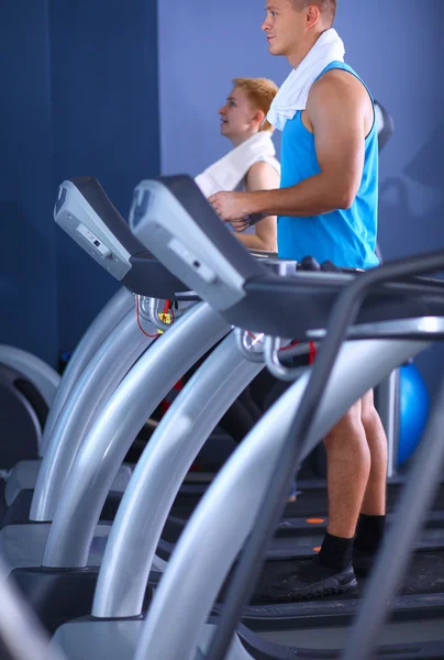 Grupo de personas en el gimnasio ejercitándose en cross trainers —  Fotos de Stock