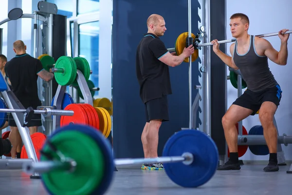 Kroppsbyggare med skivstång i gym — Stockfoto