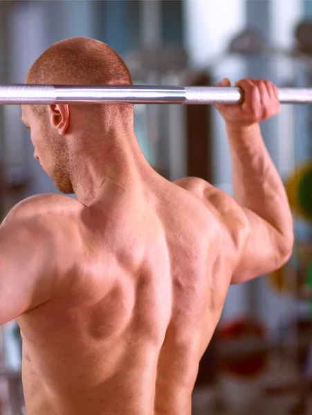 Bodybuilder met barbell in gym — Stockfoto