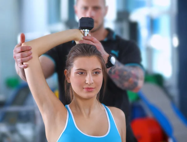 Schöne Frau im Fitnessstudio beim Training mit ihrem Trainer — Stockfoto