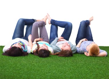 Dört genç kadın yeşil çim üzerinde yalan