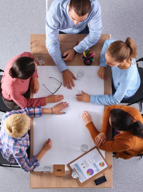 İş adamları iş toplantısında, ofiste oturup tartışıyorlar.