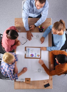 İş adamları iş toplantısında, ofiste oturup tartışıyorlar.