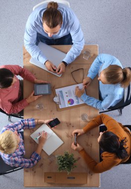 İş adamları iş toplantısında, ofiste oturup tartışıyorlar.