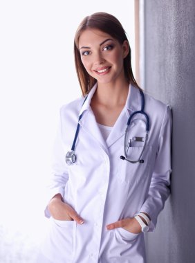 Steteskobu olan doktor kadın gri arka planda izole edilmiş.