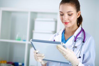 Kadın doktor hastanede dosyayla bekliyor.