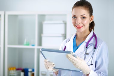 Kadın doktor hastanede dosyayla bekliyor.