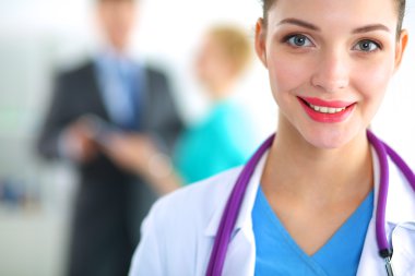 Kadın doktor hastanede steteskopla dikiliyor.