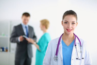 Kadın doktor hastanede steteskopla dikiliyor.