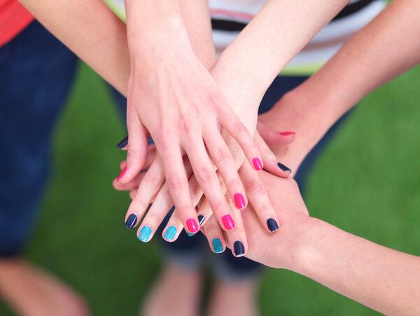 Люди, соединяющие руки на зеленой траве
