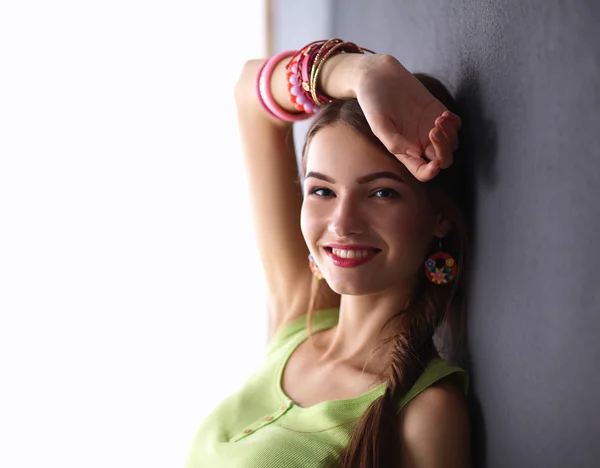 Young woman standing near dark wall — Stock Photo, Image