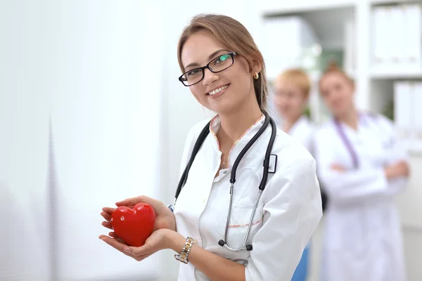 Médico com estetoscópio segurando coração, isolado em fundo branco — Fotografia de Stock