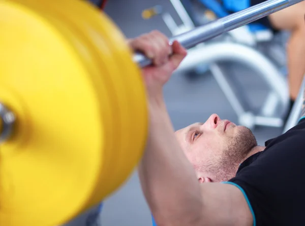 Giovane che solleva il bilanciere in palestra con l'istruttore — Foto Stock