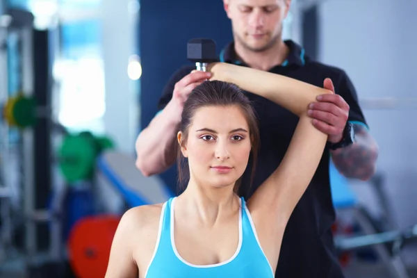 Güzel bir kadın onu antrenörü ile egzersiz jimnastik salonu — Stok fotoğraf
