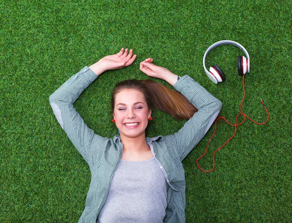 Relaxed woman  lying on the grass near headset — Stock Photo, Image