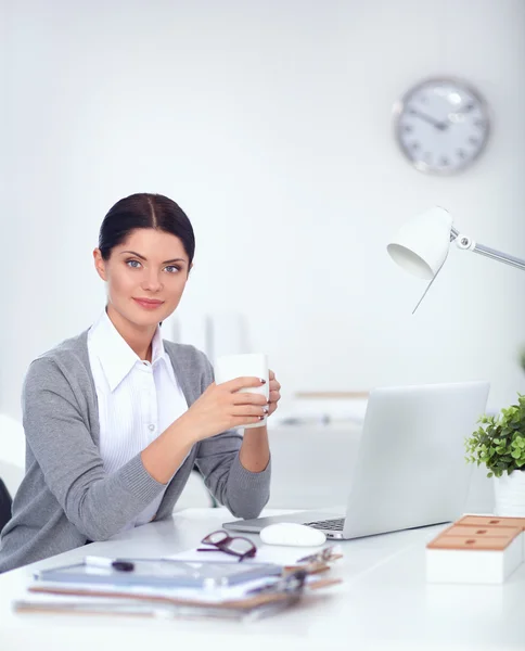 Attraktive Geschäftsfrau sitzt auf Schreibtisch im Büro — Stockfoto