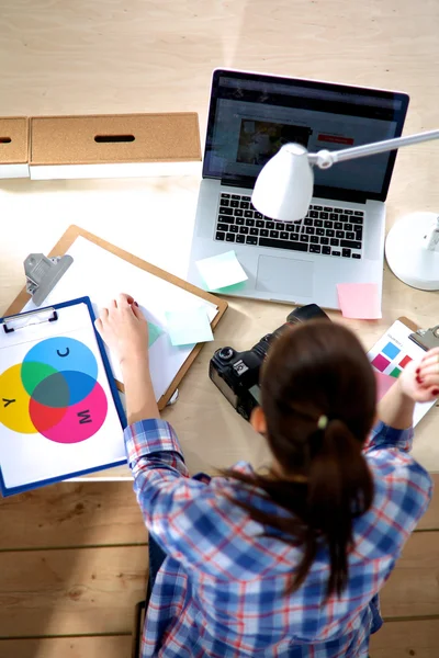 Femme photographe assise sur le bureau avec ordinateur portable — Photo