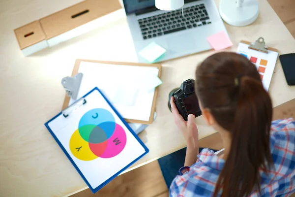 Femme photographe assise sur le bureau avec ordinateur portable — Photo