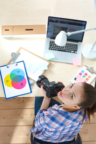 Femme photographe assise sur le bureau avec ordinateur portable — Photo