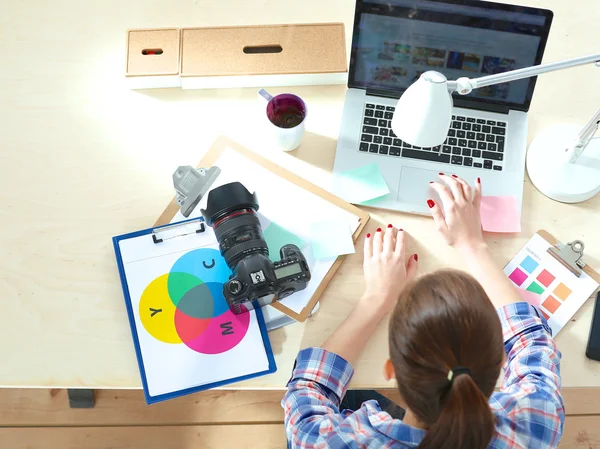 Kobieta fotograf siedzi na biurku z laptopem — Zdjęcie stockowe