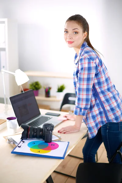 Female photographer sitting on the desk with laptop — Stock Photo, Image