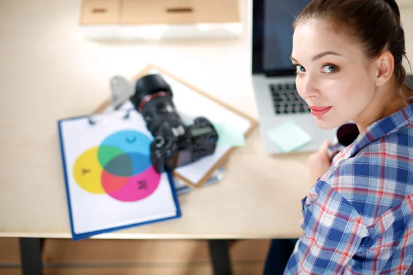 Female photographer sitting on the desk with laptop — Stock Photo, Image