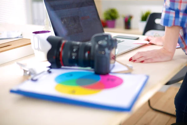 Female photographer sitting on the desk with laptop — Stock Photo, Image