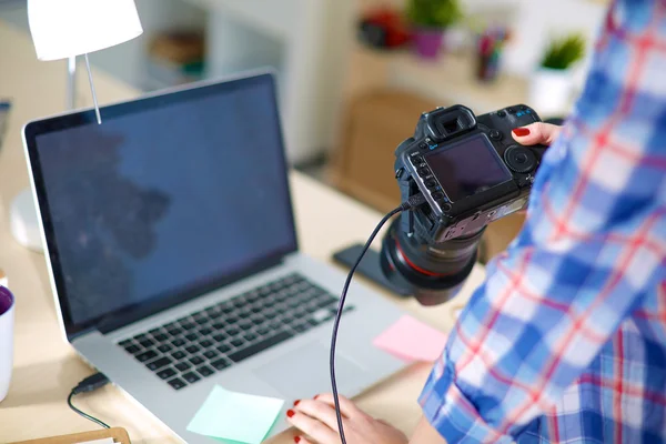 Kobieta fotograf siedzi na biurku z laptopem — Zdjęcie stockowe