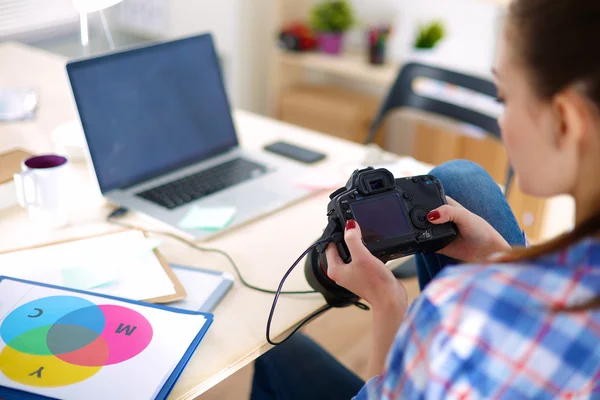 Vrouwelijke fotograaf zittend op het bureau met laptop — Stockfoto