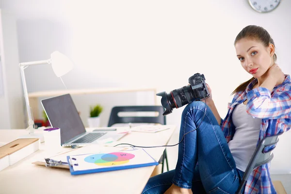 女摄影师带着笔记本电脑坐在桌子上 — 图库照片