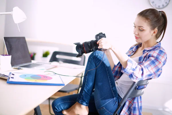 Femme photographe assise sur le bureau avec ordinateur portable — Photo