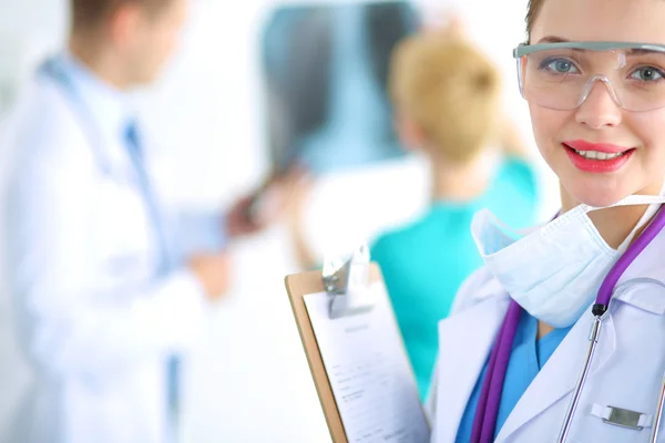 Woman doctor standing with folder at hospital — Stock Photo, Image