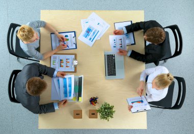 İş adamları iş toplantısında, ofiste oturup tartışıyorlar.