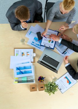 İş adamları iş toplantısında, ofiste oturup tartışıyorlar.