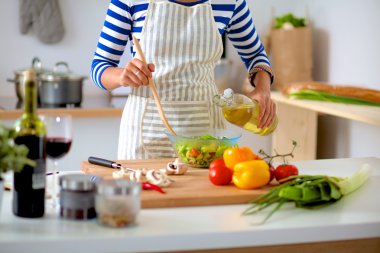 Genç kadın taze salata hazırlıyor.