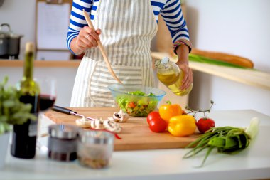 Genç kadın taze salata hazırlıyor.