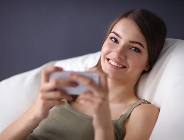 Mooie vrouw in haar woonkamer liggend op de bank verzenden puinhoop — Stockfoto