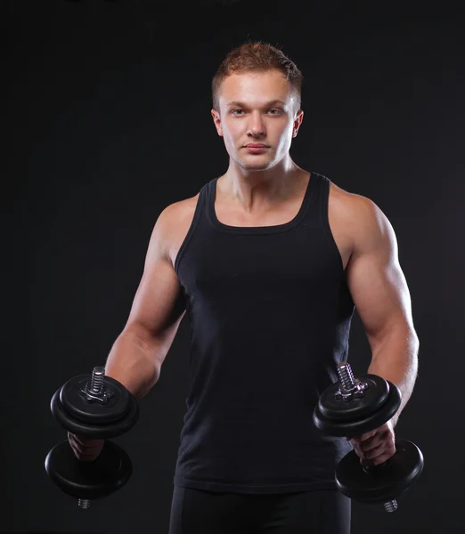 Handsome muscular man working out with dumbbells — Stock Photo, Image